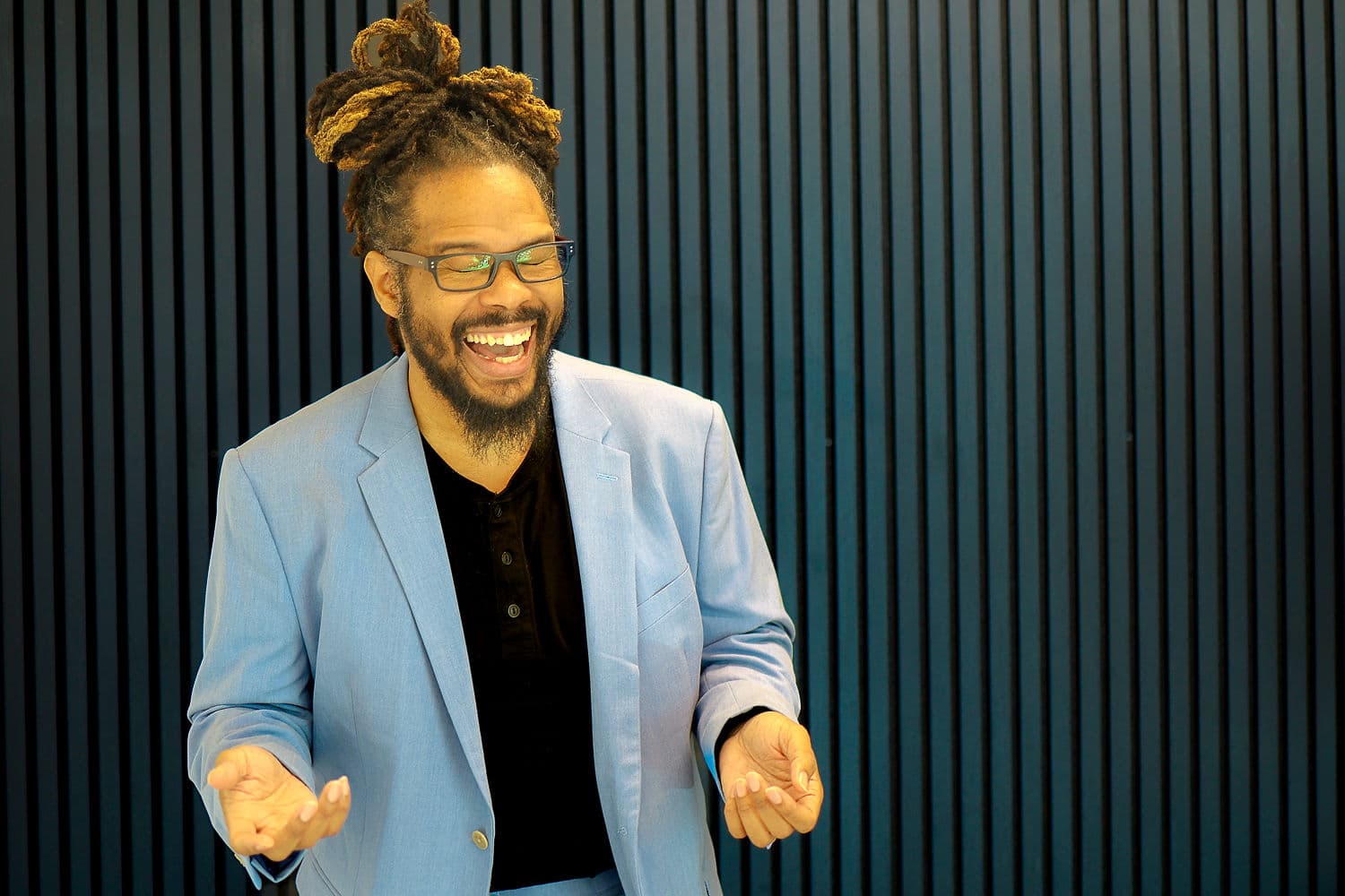 Gregory Rutledge laughing in a blue suit