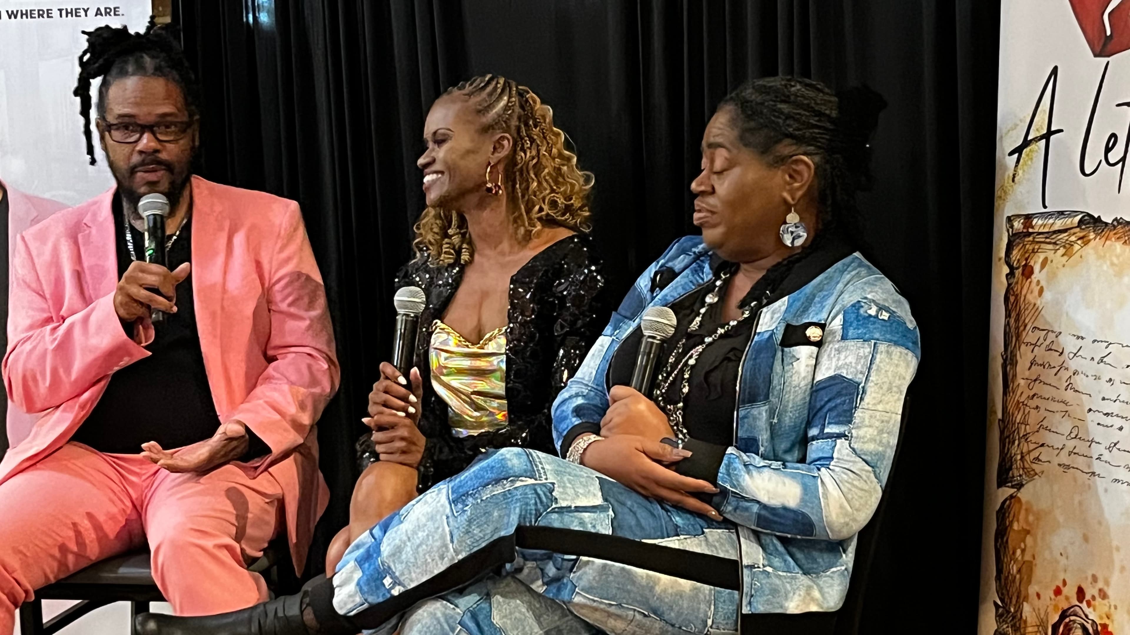 Gregory Rutledge speaking on a panel with a microphone