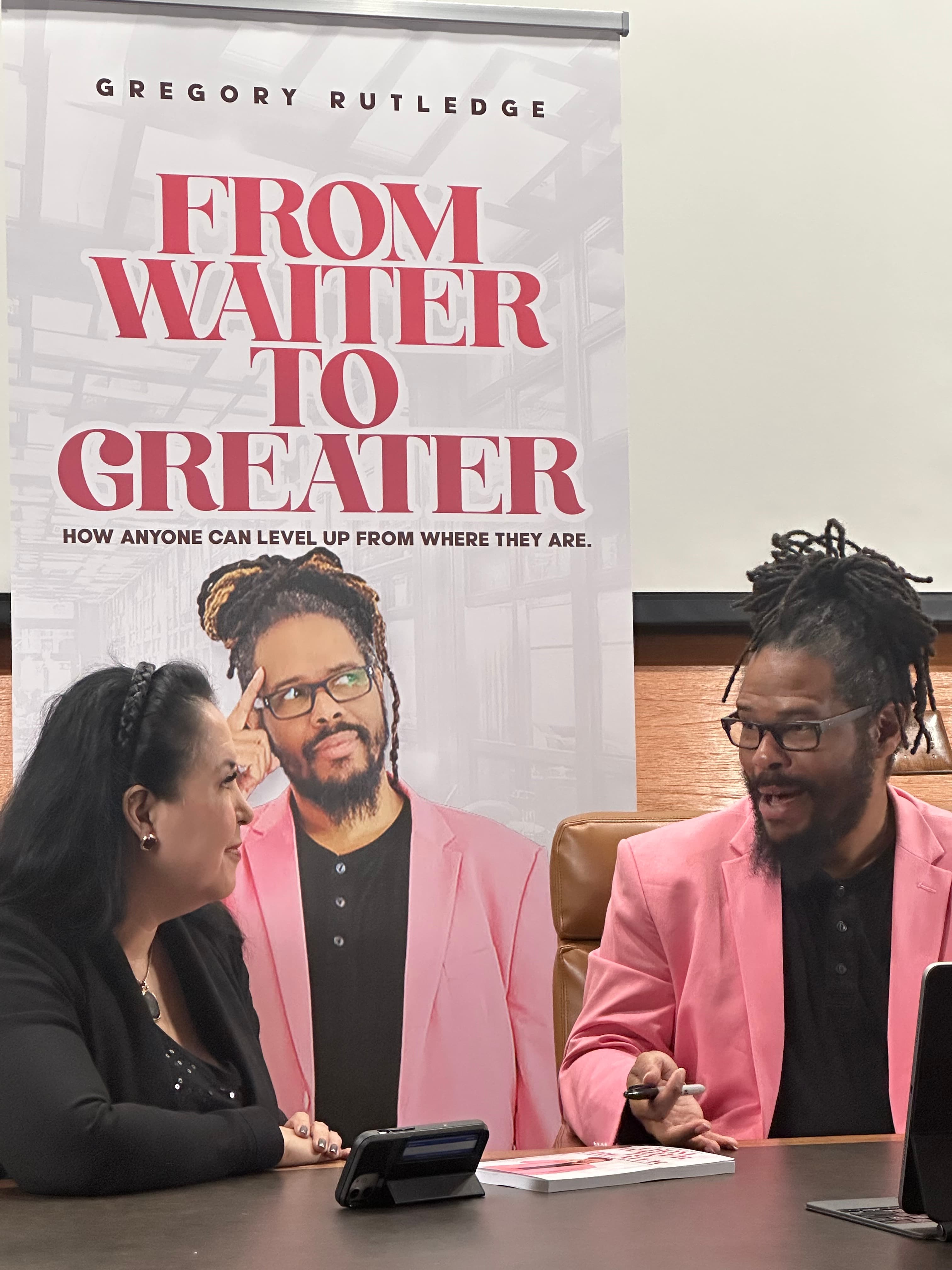 Gregory Rutledge signing copies of From Waiter to GREATER