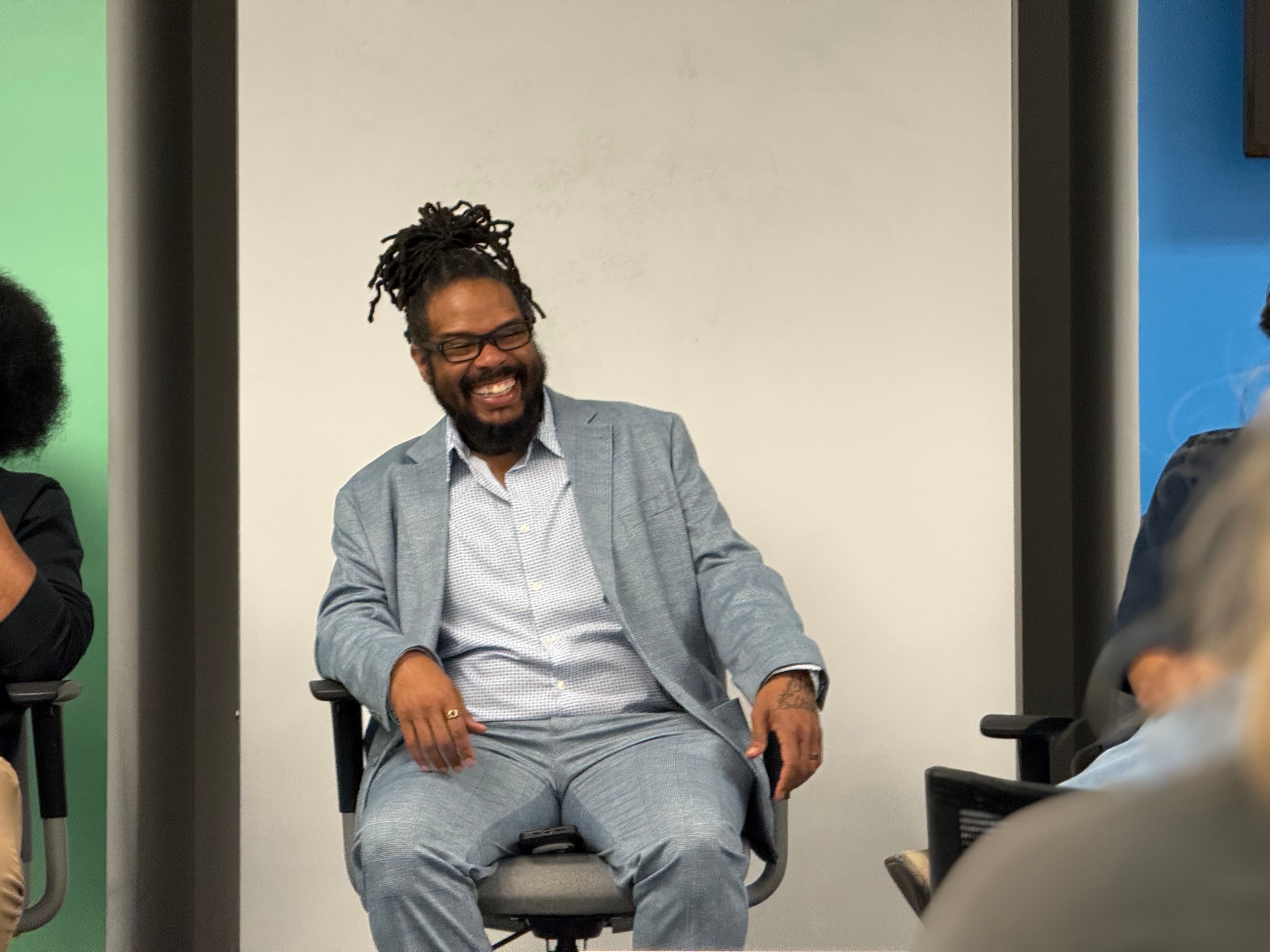 Gregory Rutledge laughing in front of a room during a live session