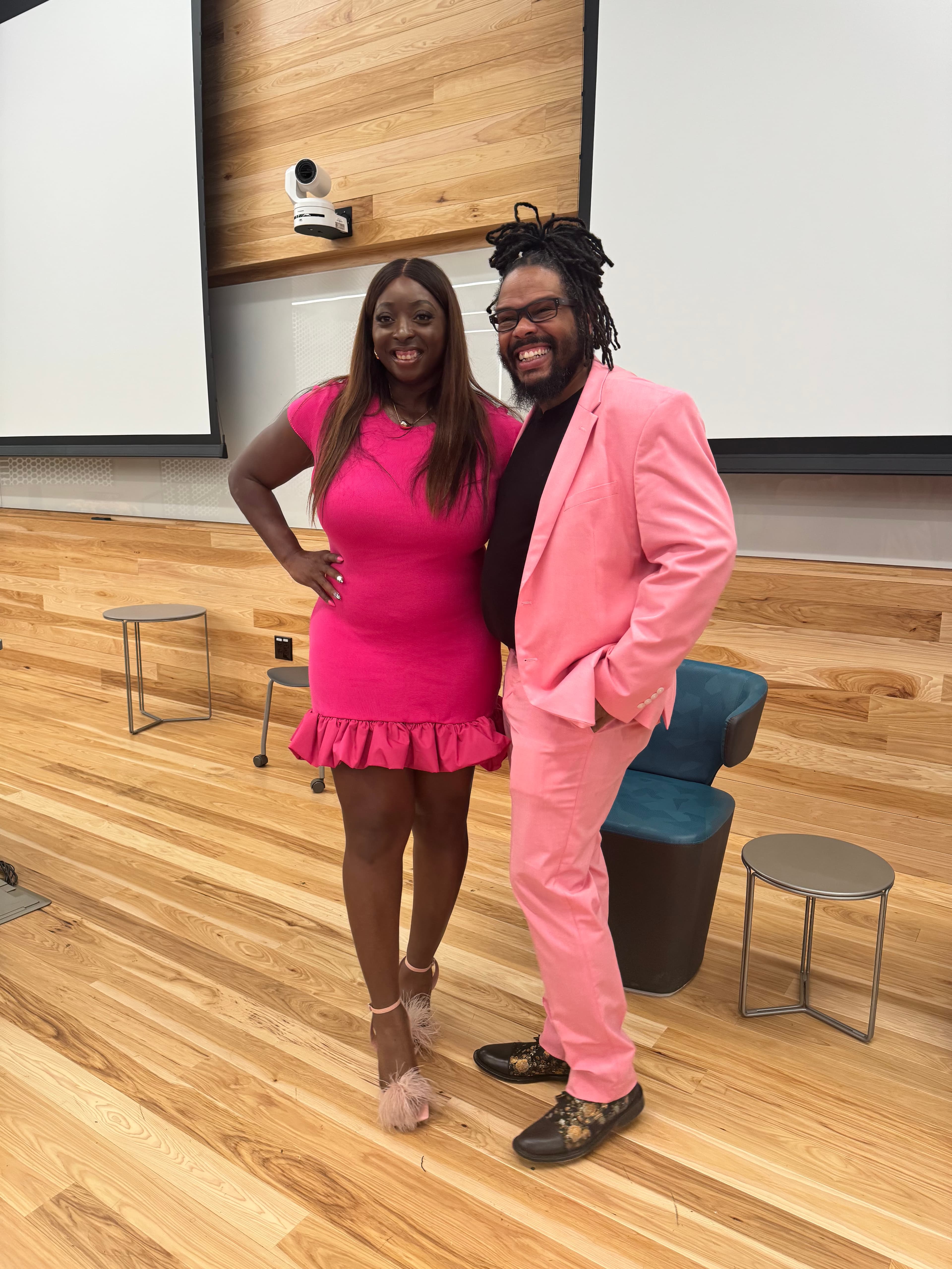 Gregory Rutledge and a guest in matching pink at a live event